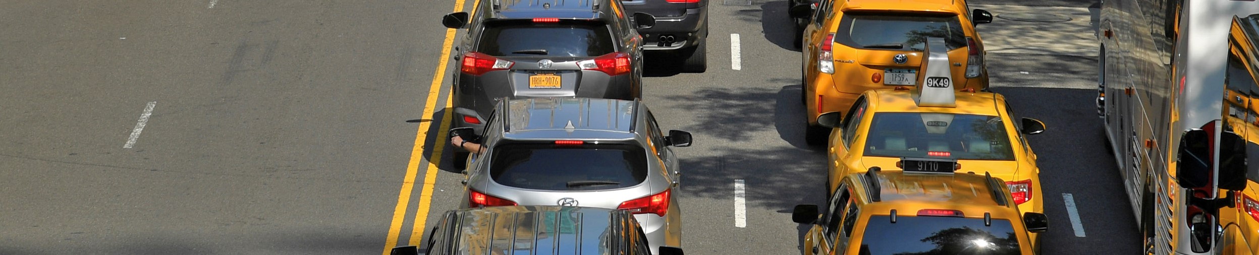Lines of taxis, private cars and other vehicles sit bumper-to-bumper on a roadway