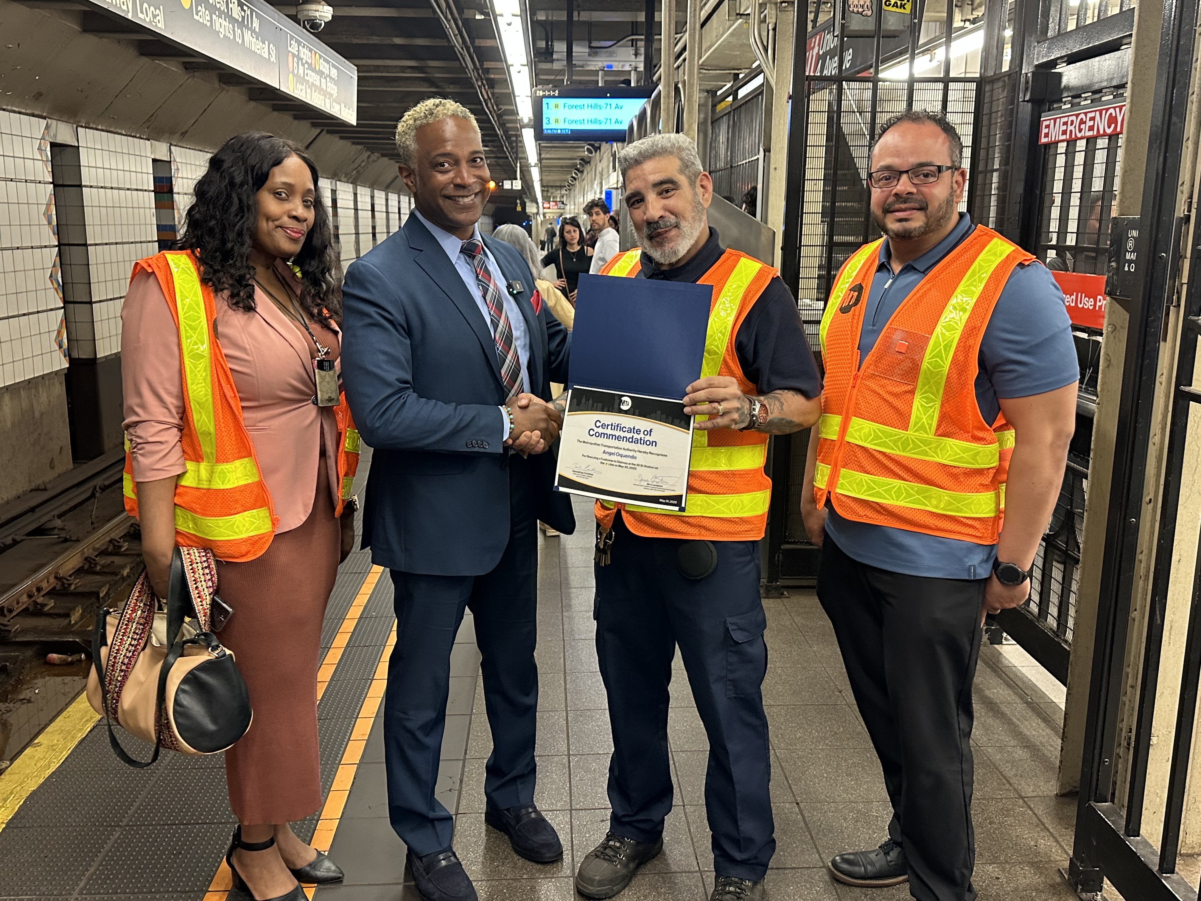Metropolitan Transportation Authority (MTA) New York City Transit (NYCT) Senior Vice President of Subways Demetrius Crichlow presented NYCT Cleaner Angel Oquendo with a Certificate of Commendation for rescuing a customer in distress at the 25 St R station in Brooklyn on Tuesday, May 30. 
